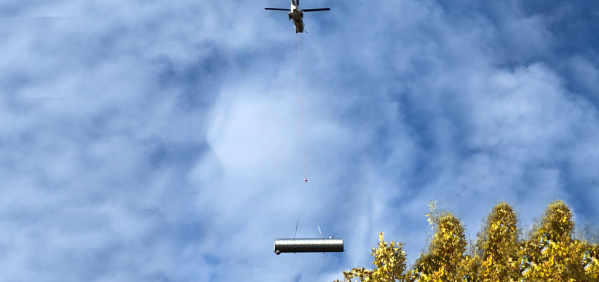 Une citerne CSTUBAO est transportée par un hélicoptère jusqu'à son site d'installation.